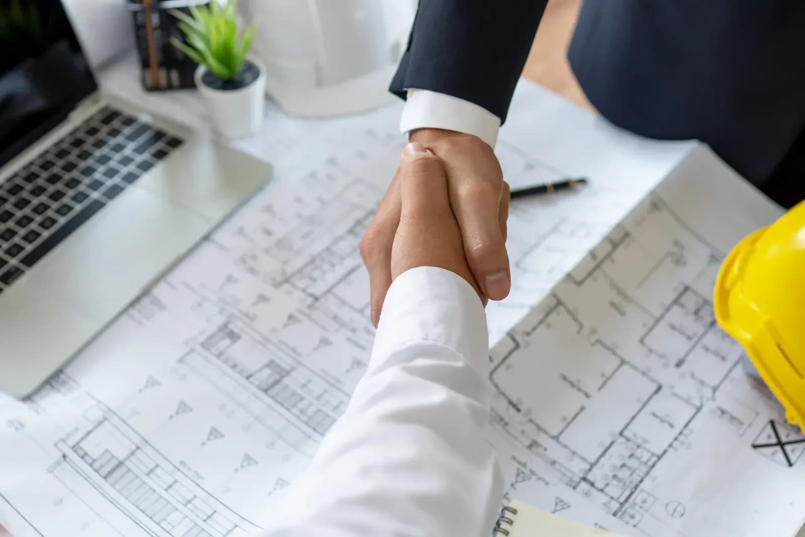 Handshake over architectural plans